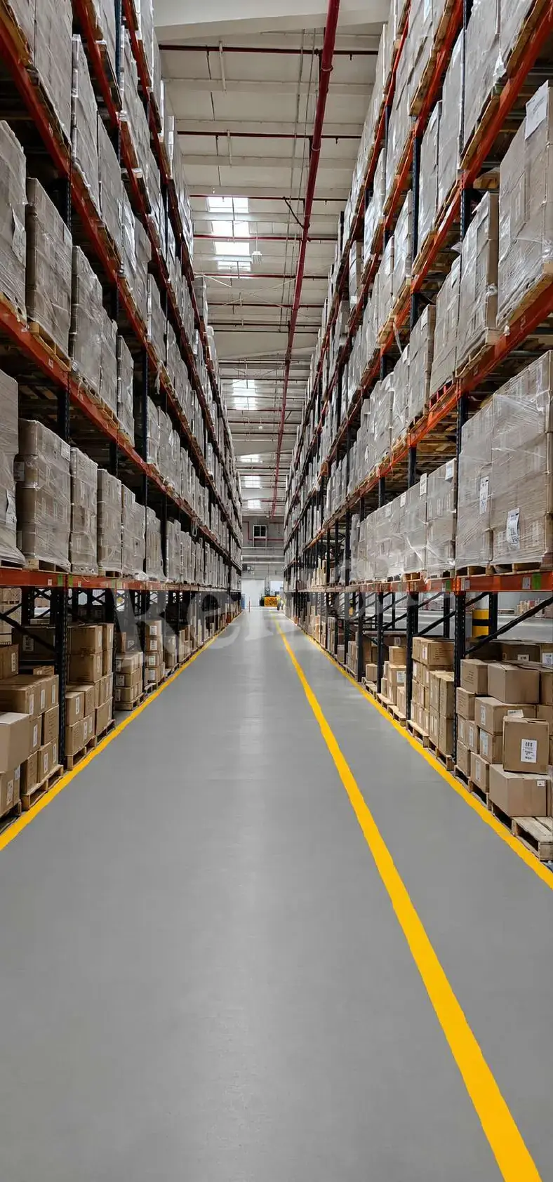 Pasillo de almacén con racks industriales cargados con tarimas