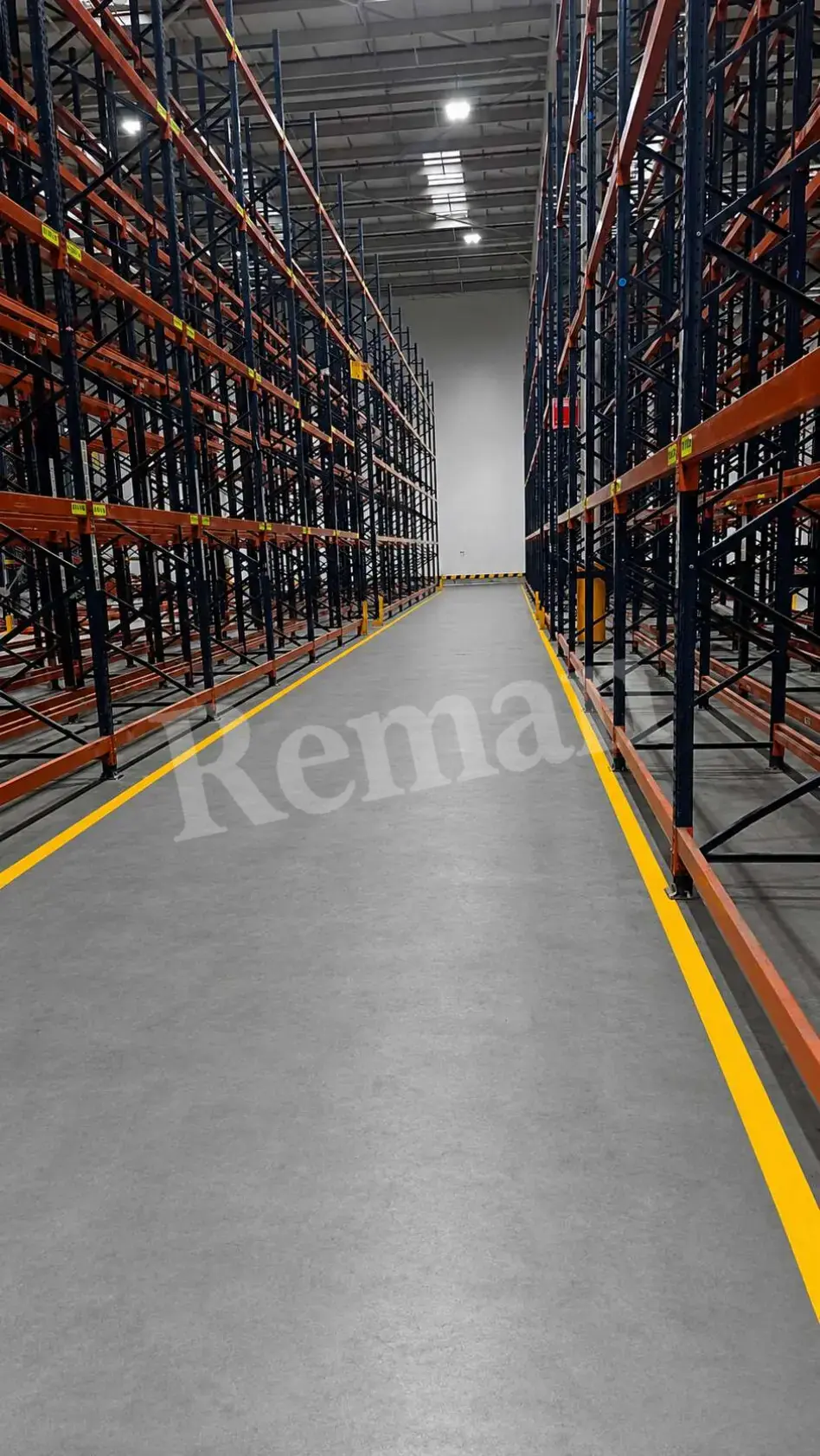 Pasillo entre estructuras de rack industrial azul y naranja